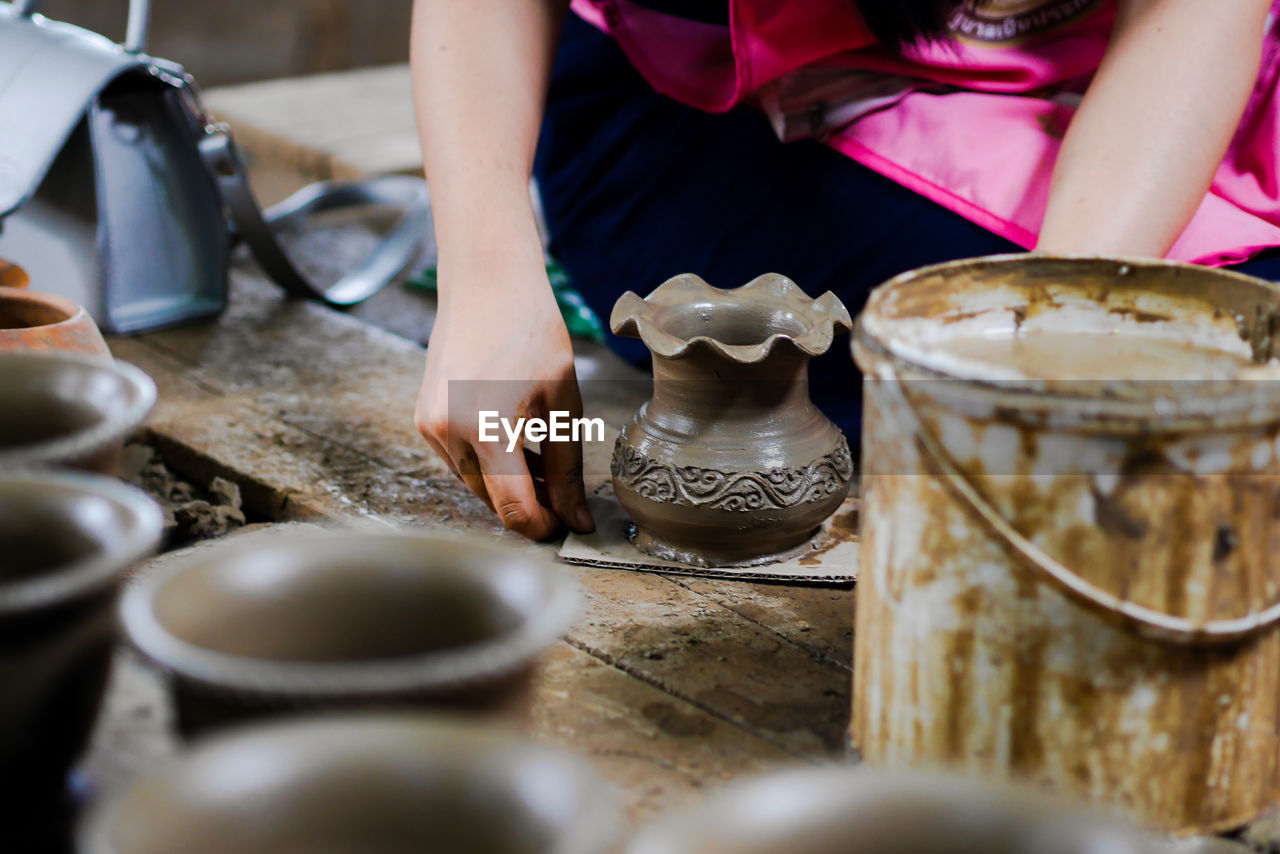 Midsection of woman making flower pot