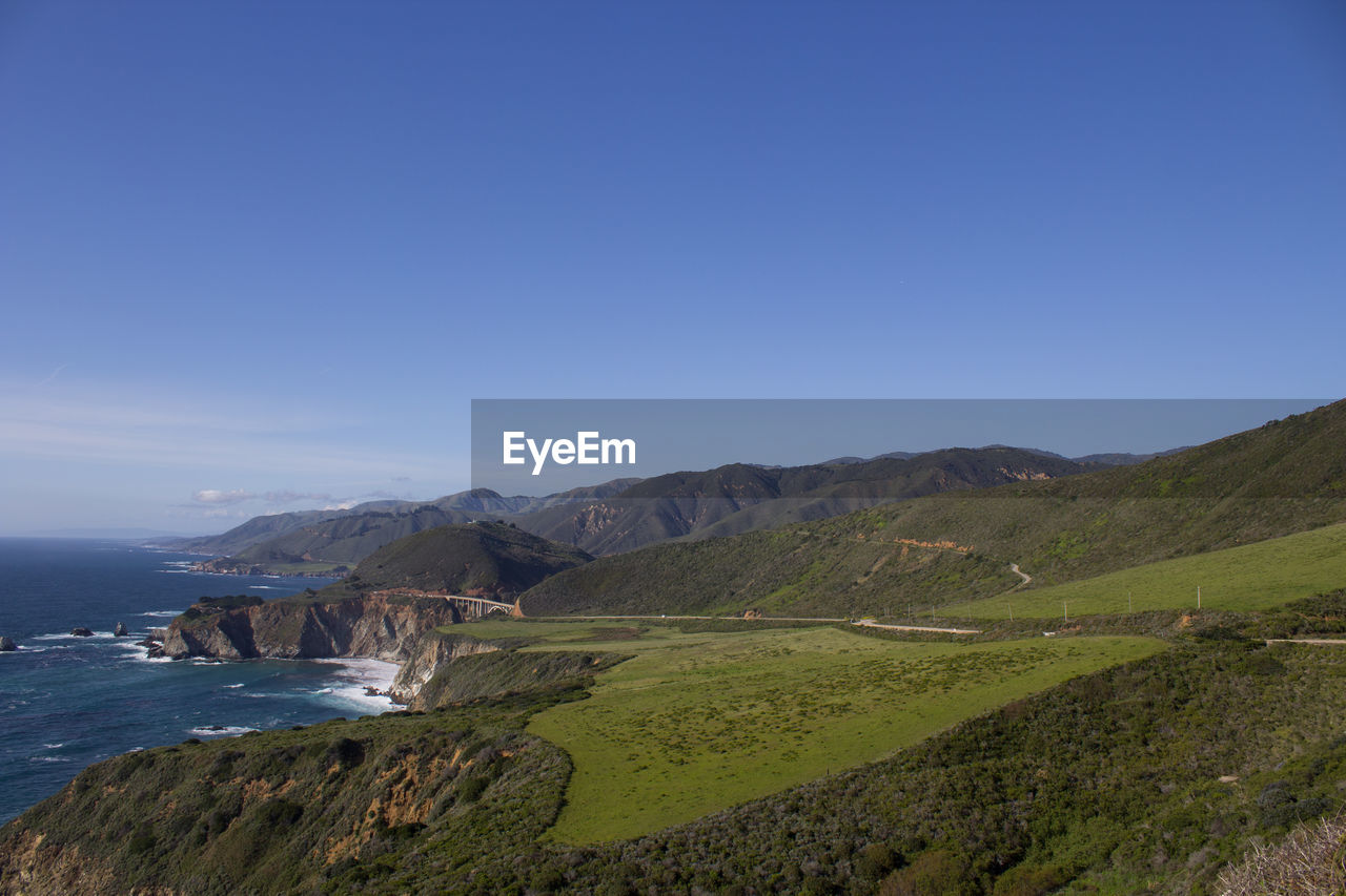 SCENIC VIEW OF LAND AND SEA AGAINST CLEAR BLUE SKY