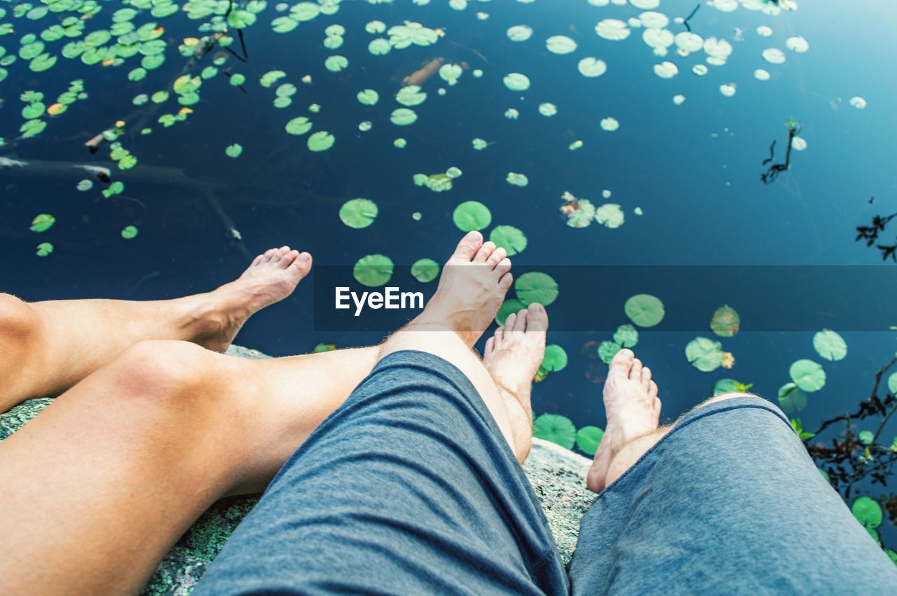 Low section of man and woman relaxing over water