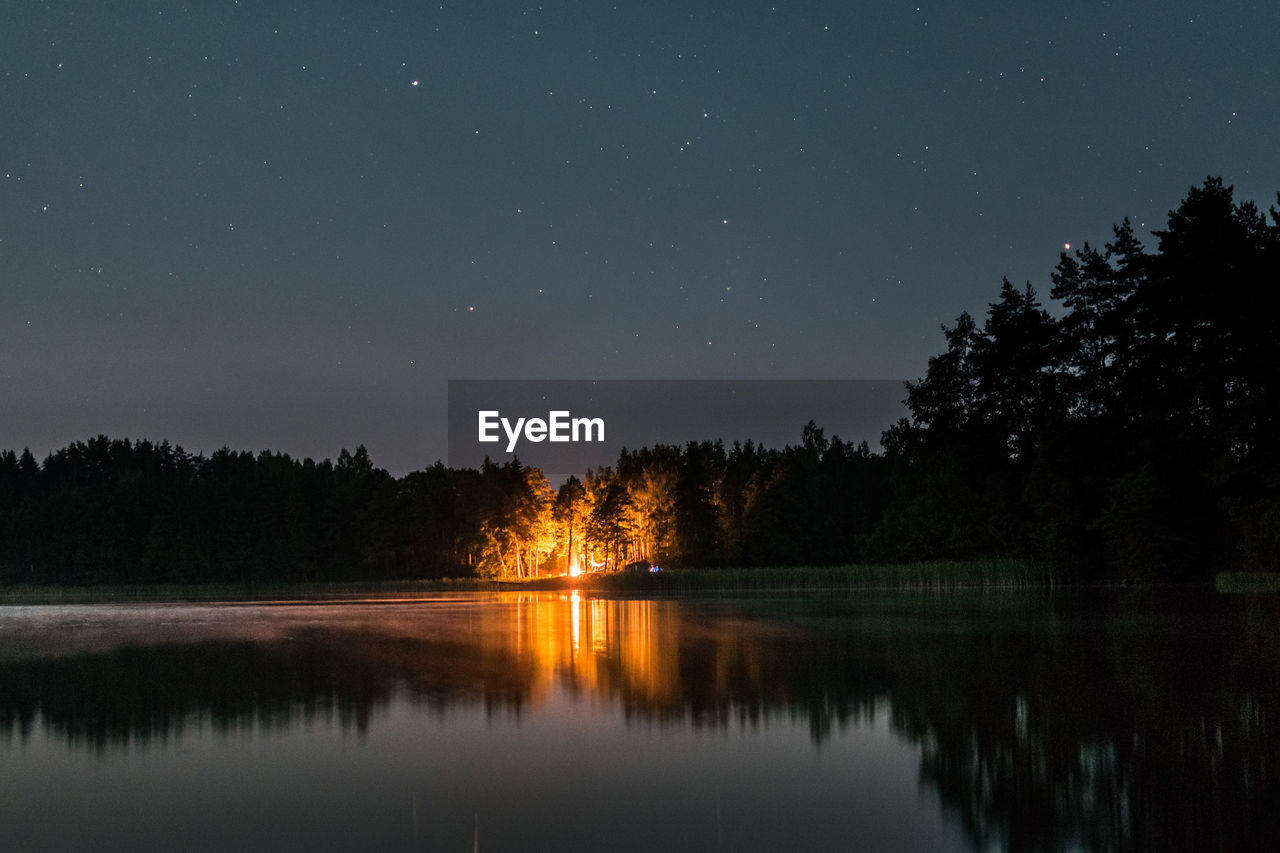 Scenic view of lake against sky at night