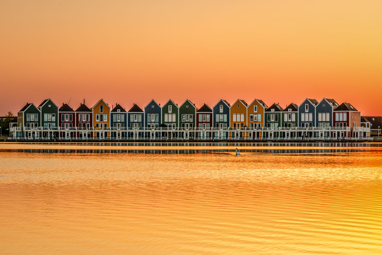 Colorful wooden rainbow houses at sunset in houten, a little suburb of utrecht in south holland