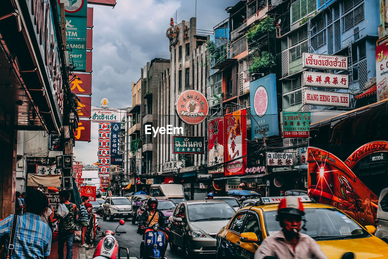 Traffic on street amidst buildings in city