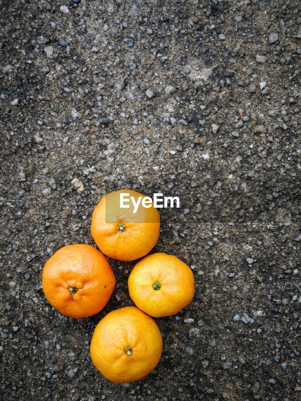 HIGH ANGLE VIEW OF ORANGE FRUITS ON GROUND