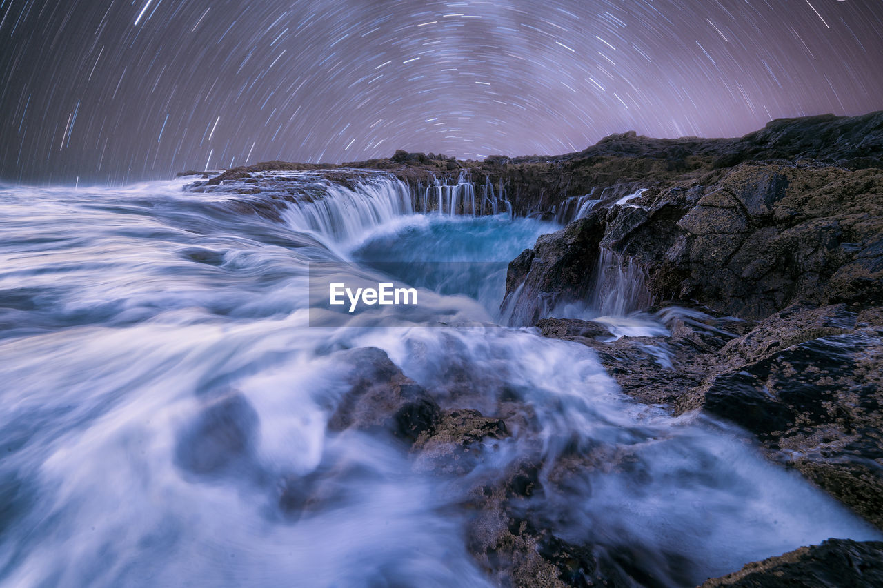 Scenic view of waterfall against sky