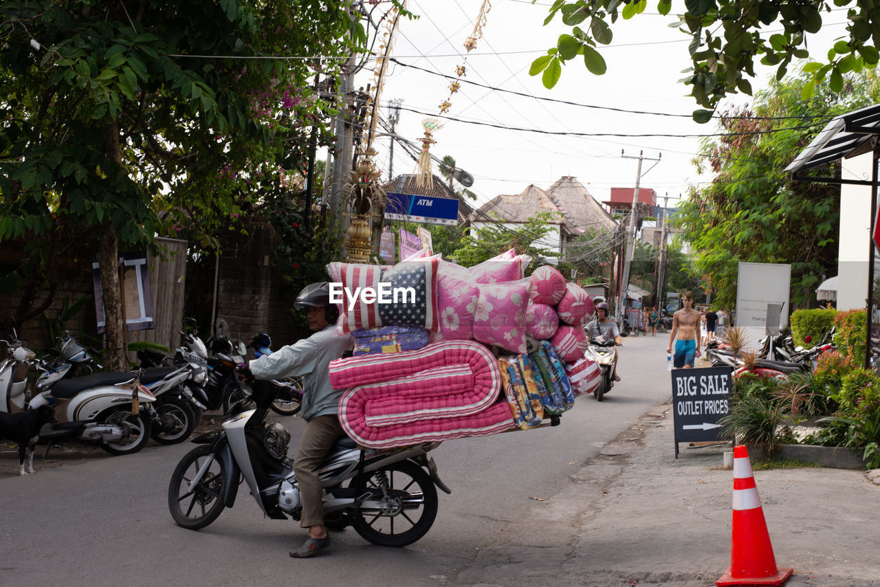 REAR VIEW OF MAN RIDING BICYCLE ON STREET