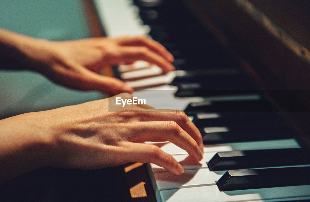 Close-up of hands playing piano