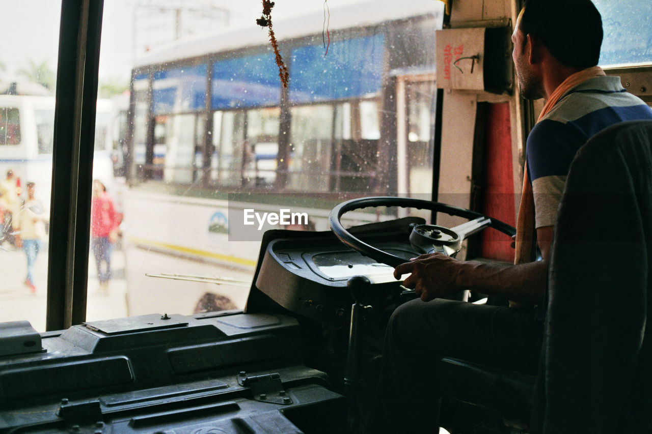 Man driving bus in city