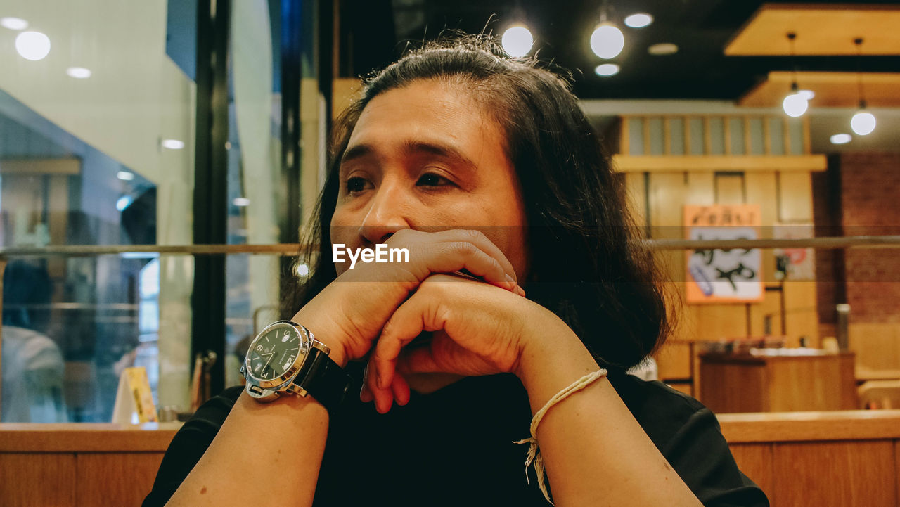 PORTRAIT OF WOMAN ON ILLUMINATED RESTAURANT