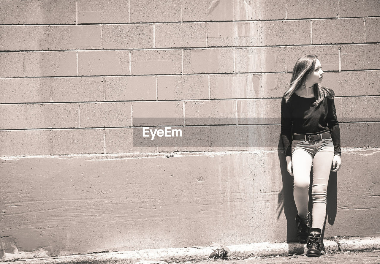 Full length of teenage girl leaning on wall