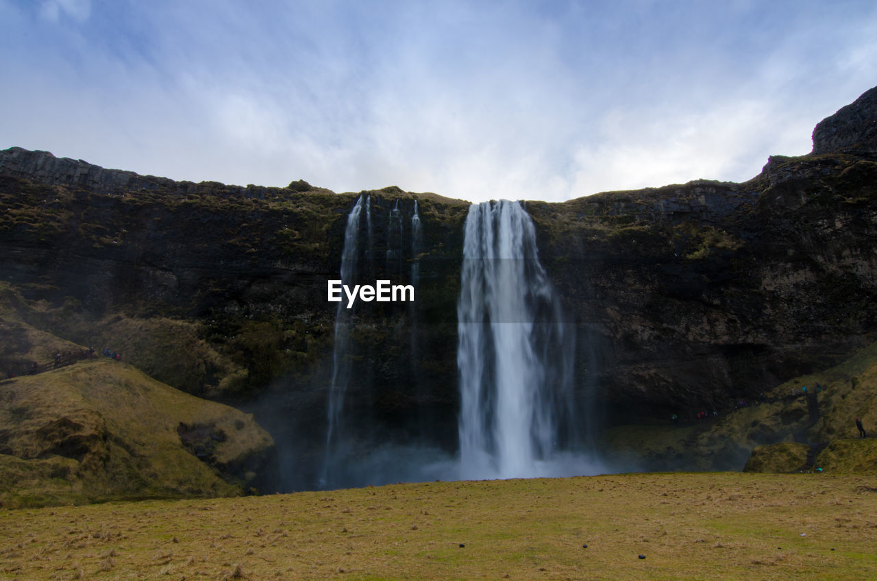 SCENIC VIEW OF WATERFALL AGAINST ROCKS