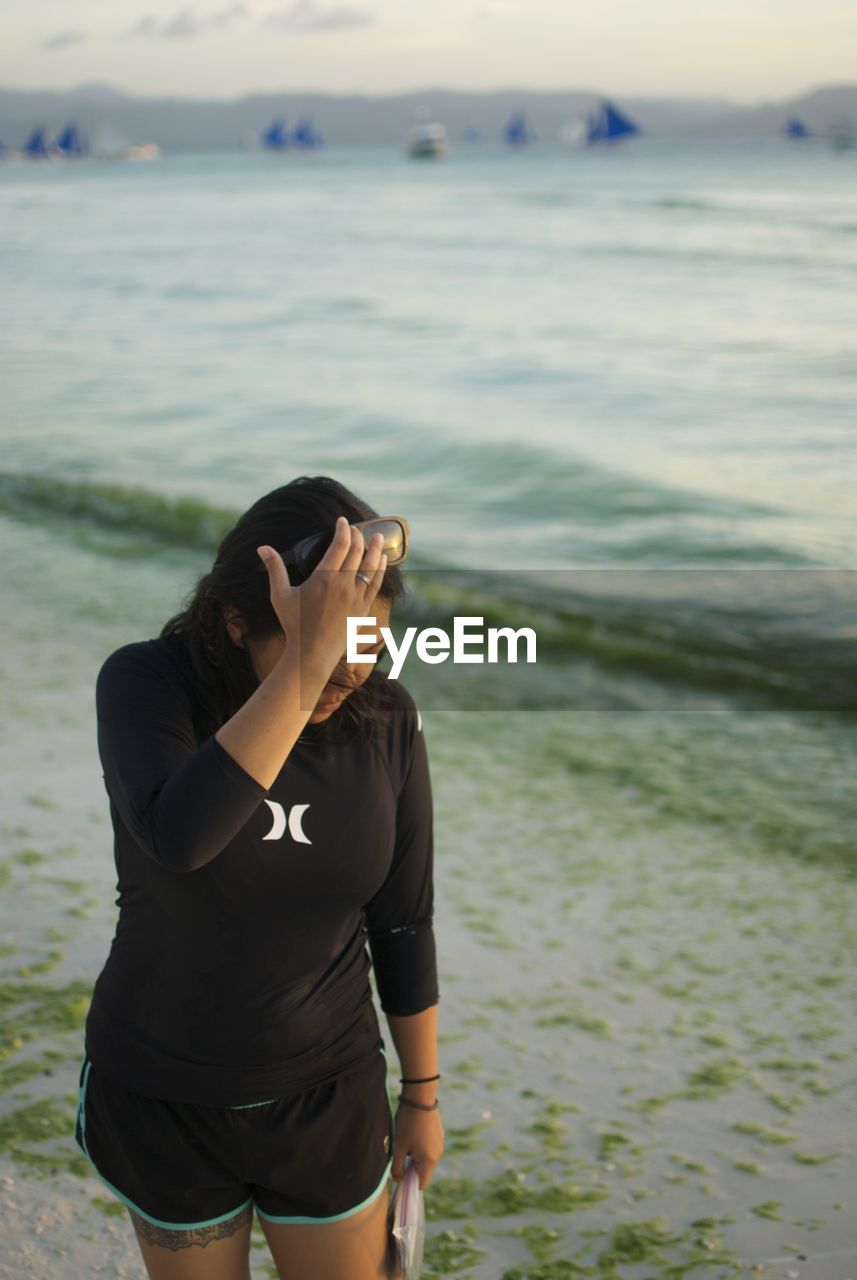 MAN STANDING AT BEACH