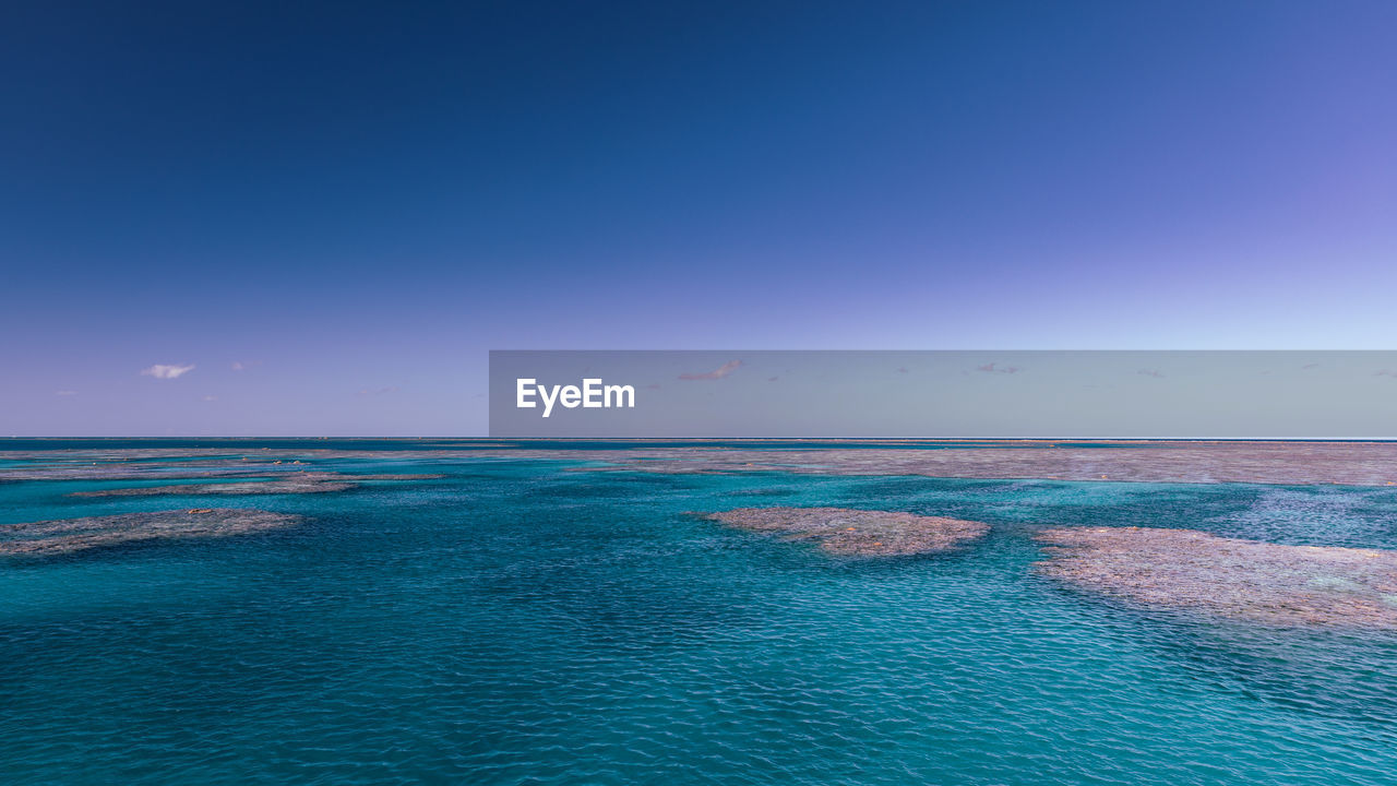 Scenic view of sea against clear blue sky