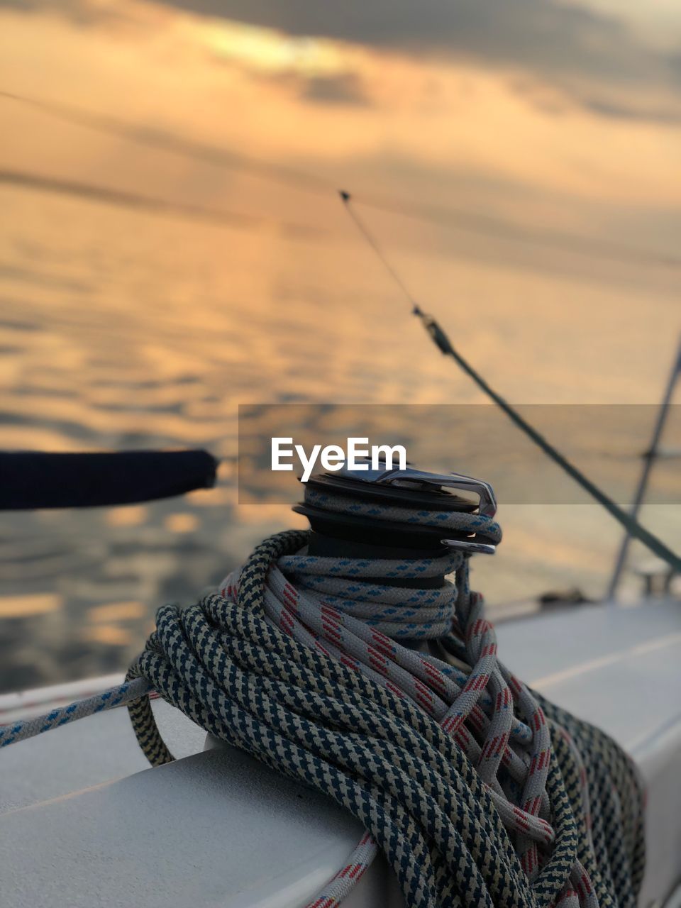 Rope tied on boat at sea during sunset