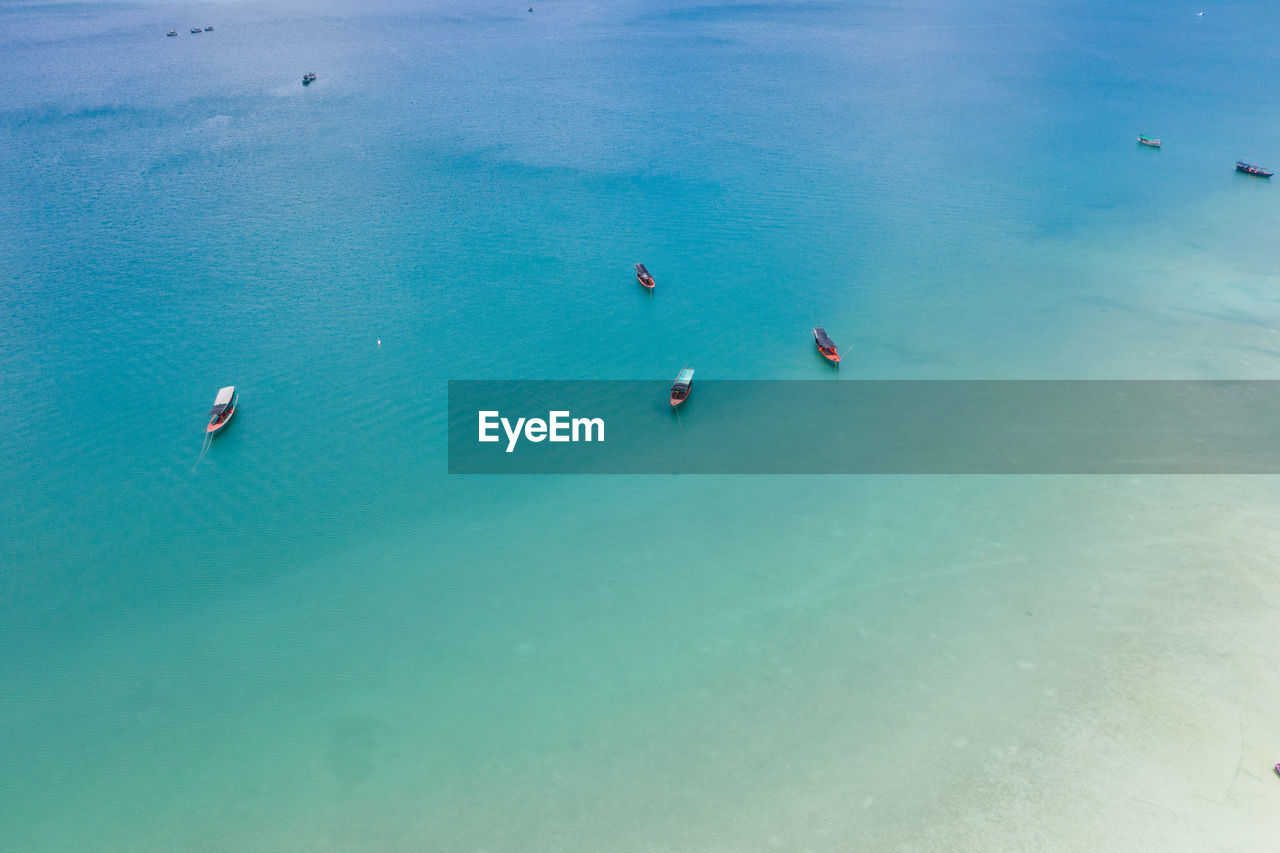 HIGH ANGLE VIEW OF BOATS IN SEA