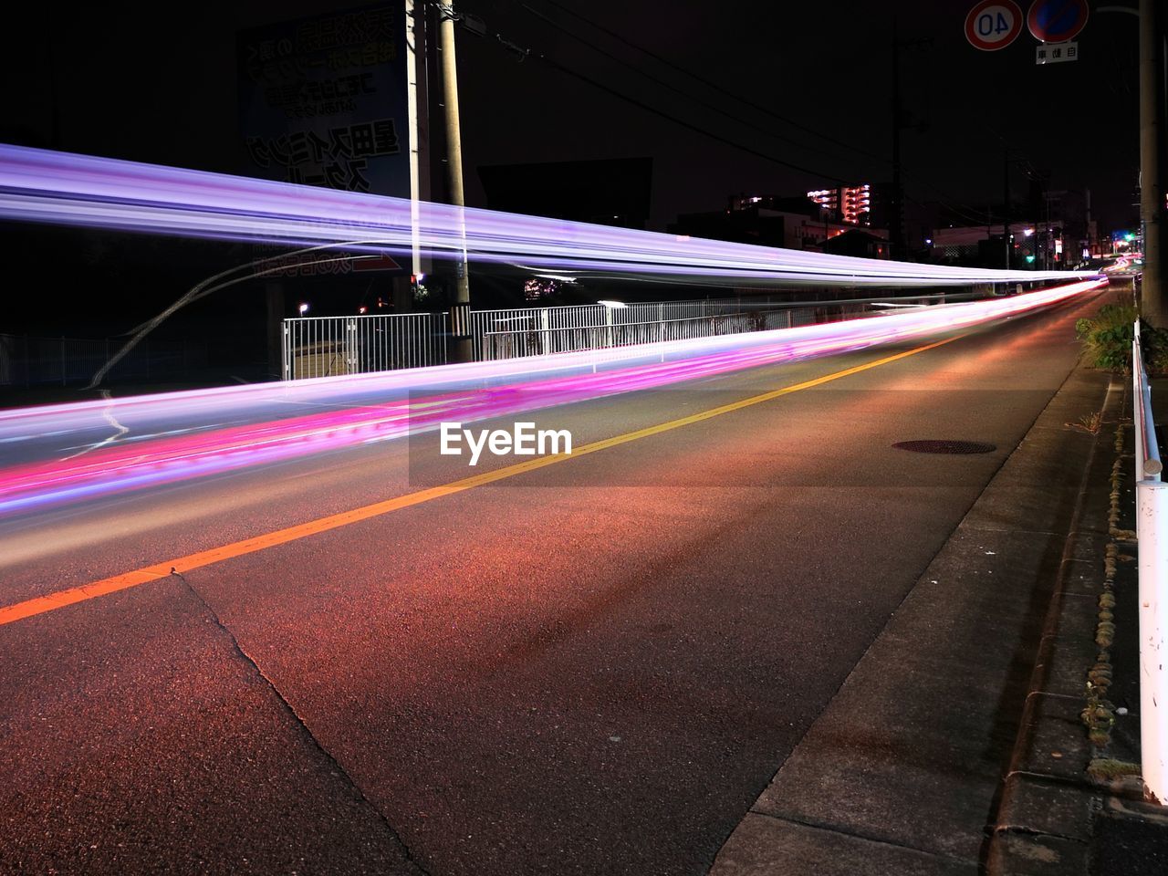 LIGHT TRAILS ON STREET AT NIGHT