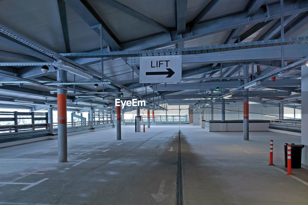 architecture, built structure, transport, transportation, indoors, industry, no people, parking lot, factory, warehouse, sport venue, building, domestic room, empty, sign, public transport, parking, business, city, infrastructure, day, mode of transportation, absence