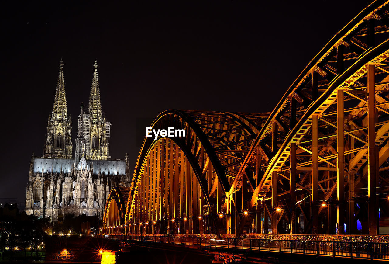 LOW ANGLE VIEW OF ILLUMINATED BRIDGE AGAINST SKY