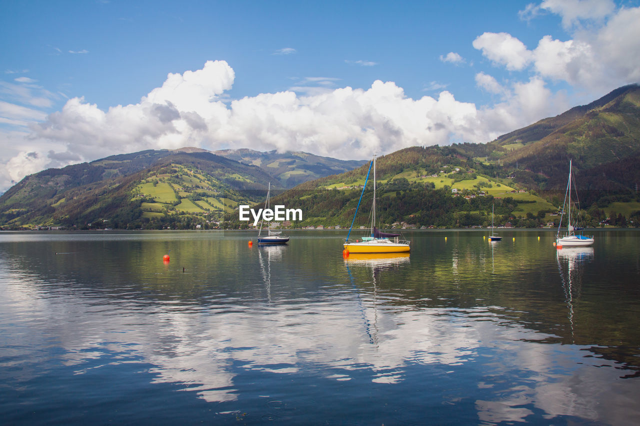 SAILBOATS ON LAKE AGAINST SKY