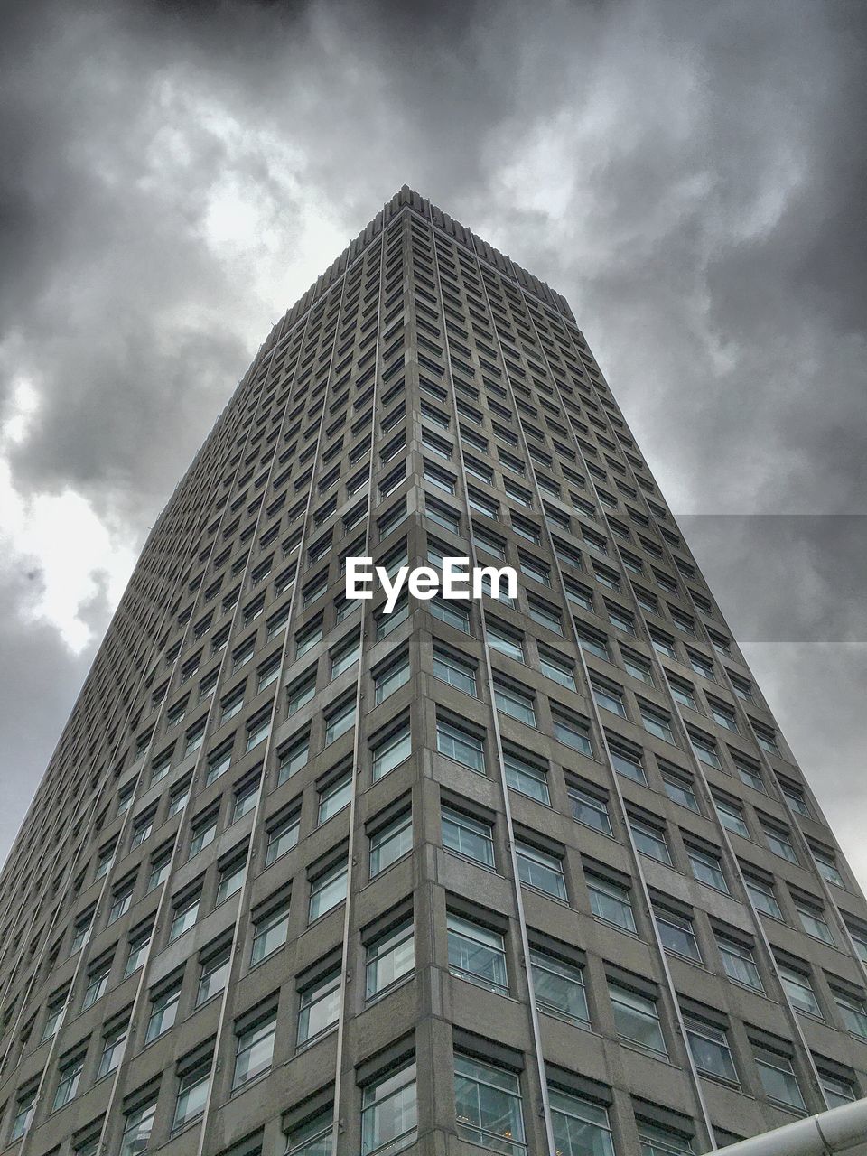 Low angle view of modern building against cloudy sky