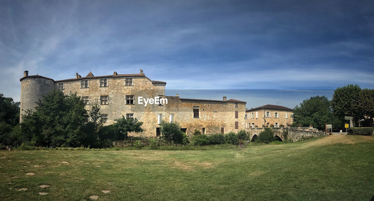 HOUSES ON FIELD AGAINST SKY