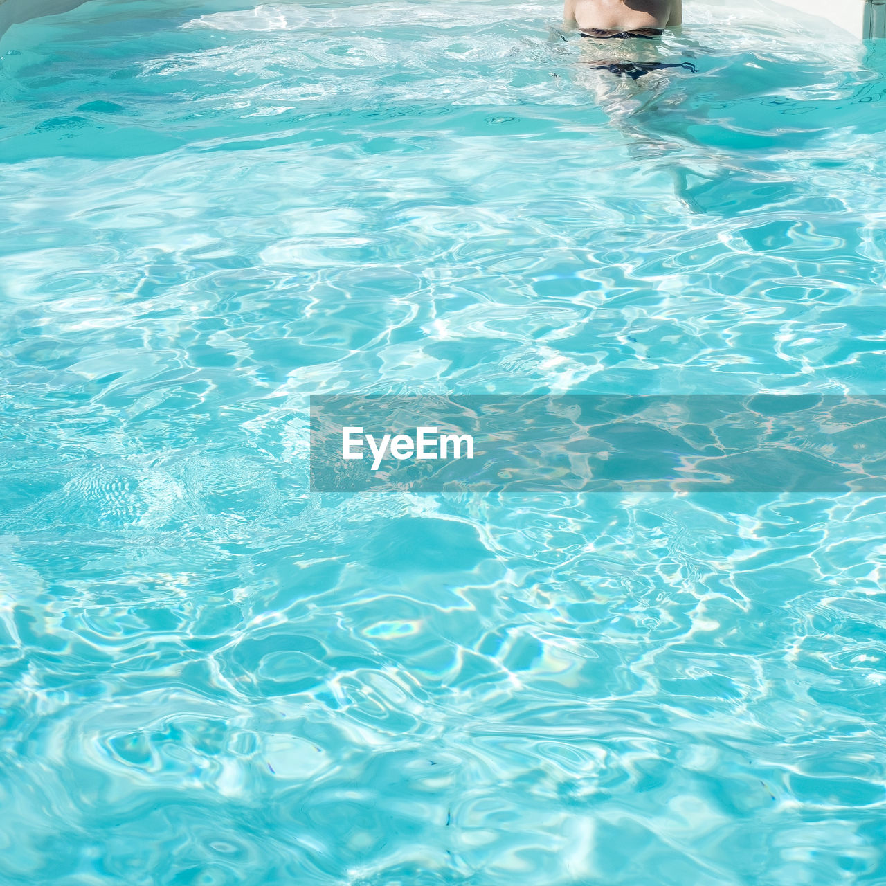 Cropped image of woman wearing bikini in swimming pool