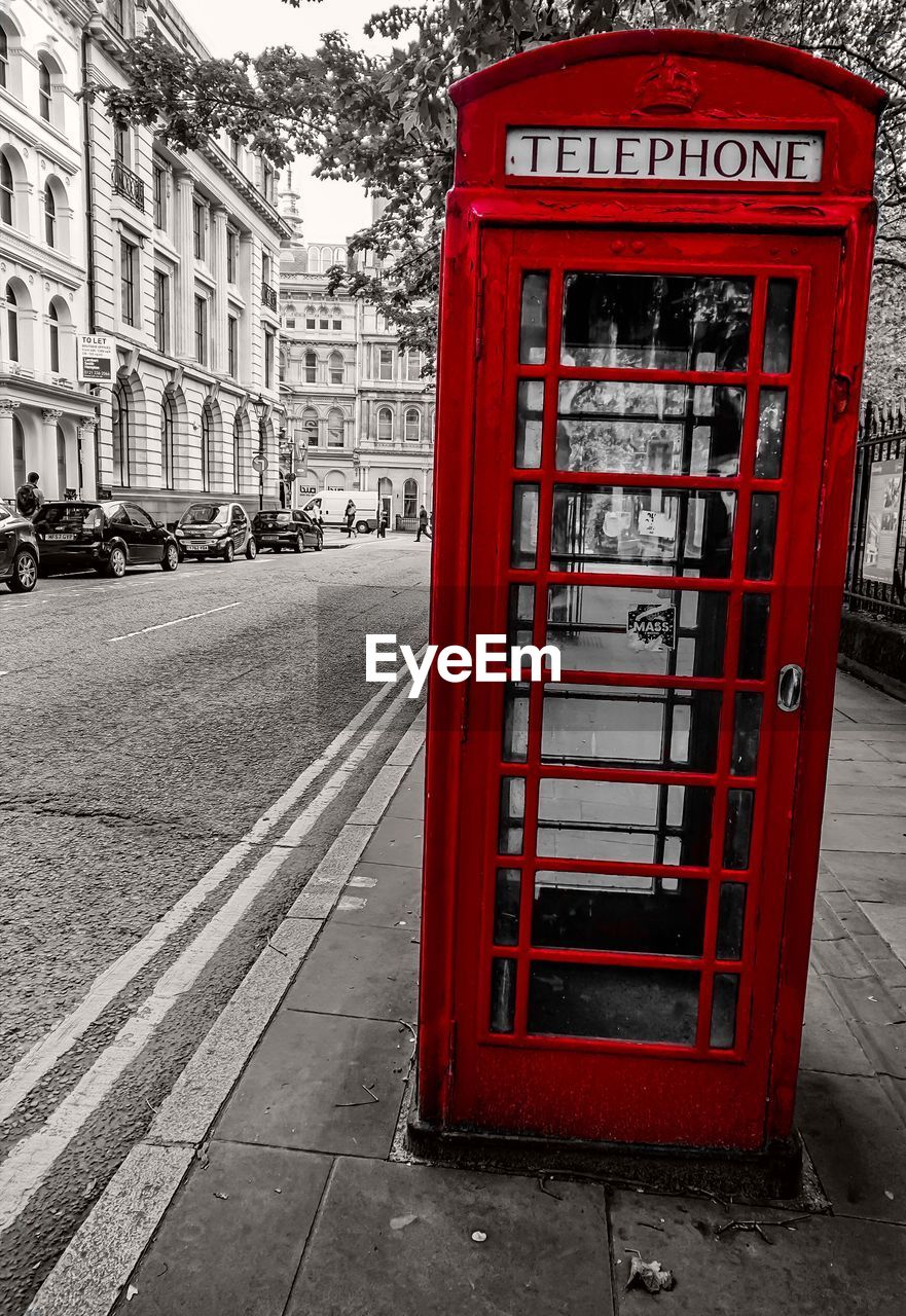 RED TELEPHONE BOOTH ON SIDEWALK