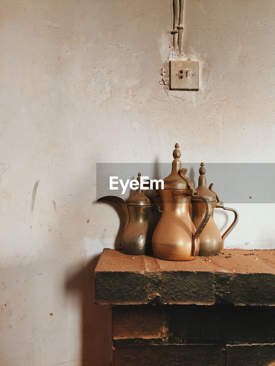 Containers on fireplace against wall