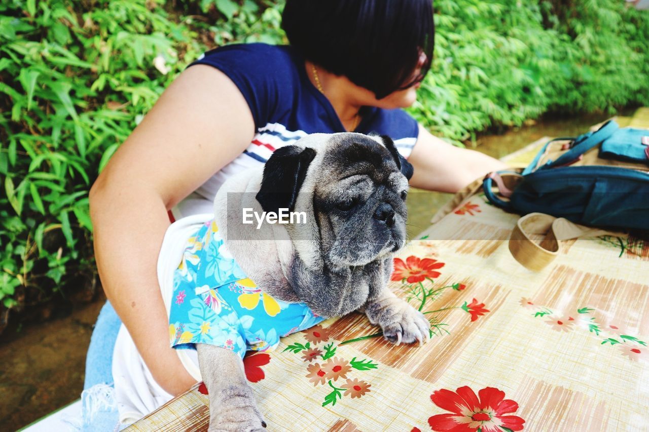 Woman holding dog on table