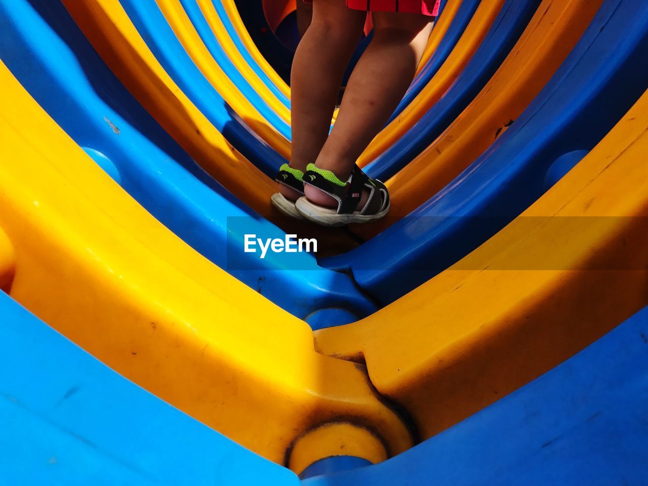 LOW SECTION OF BOY PLAYING ON SLIDE