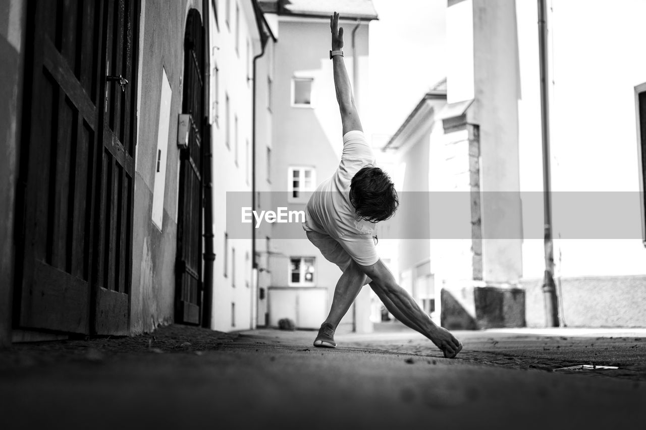 Young man exercising by building