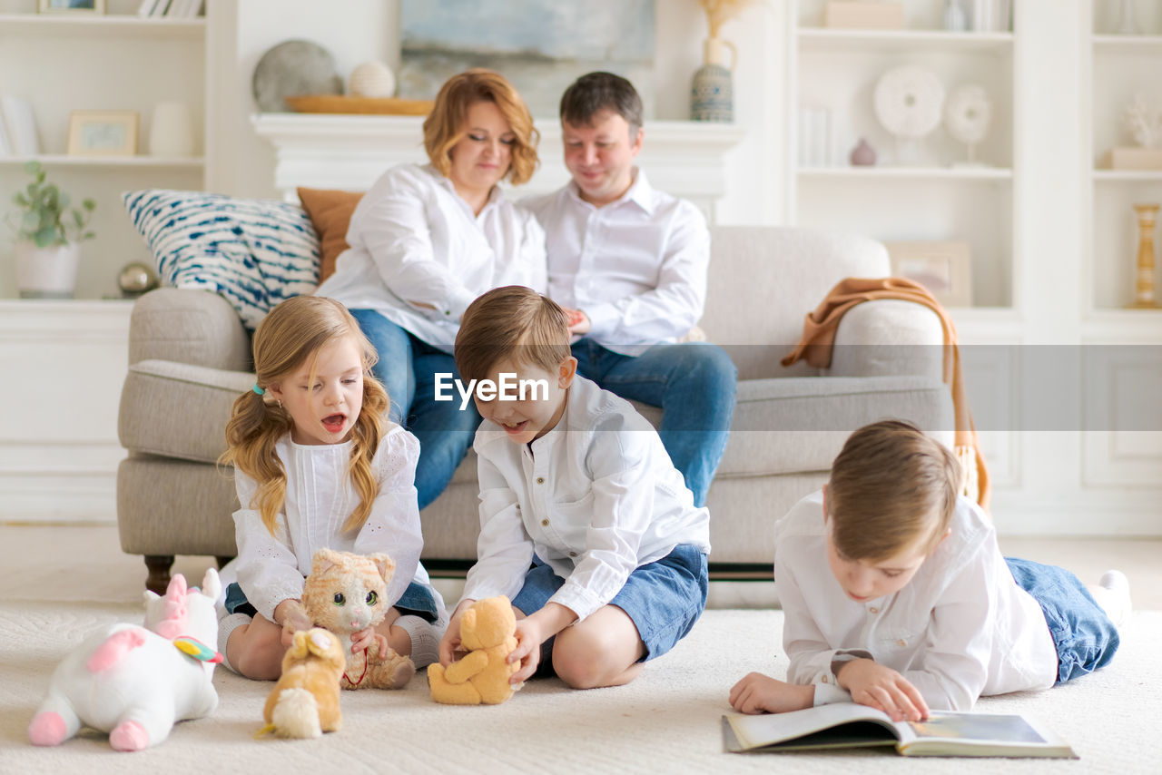 Happy young caucasian family resting in a new cozy design home on weekends.