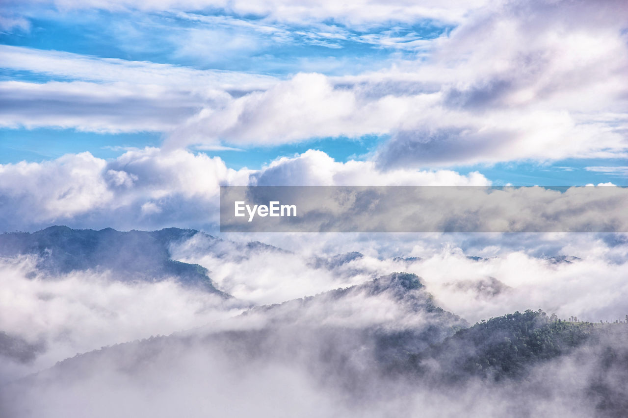 Scenic view of clouds over mountains against sky