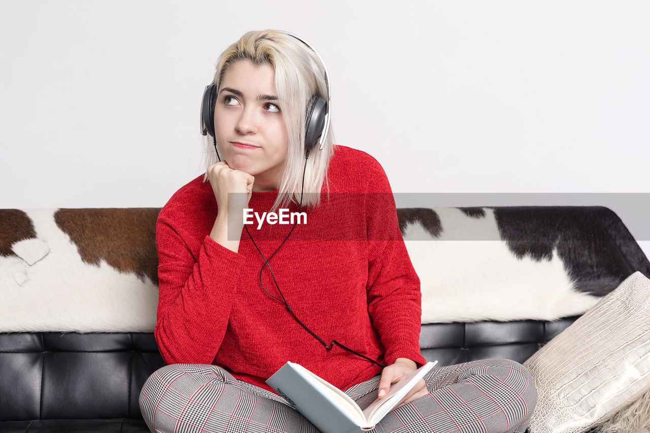 portrait of young woman sitting on sofa at home