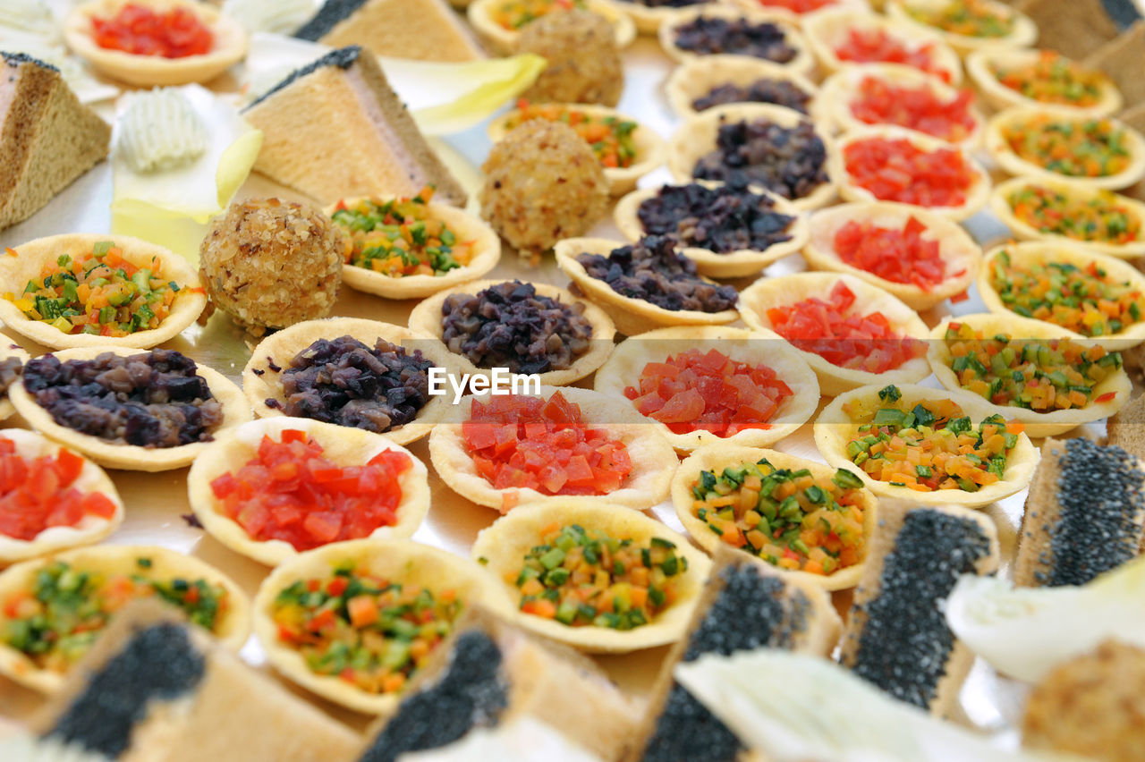 Full frame of savory canapés with colored vegetables