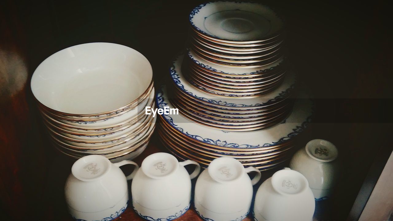 High angle view of stacked ceramics in shelf