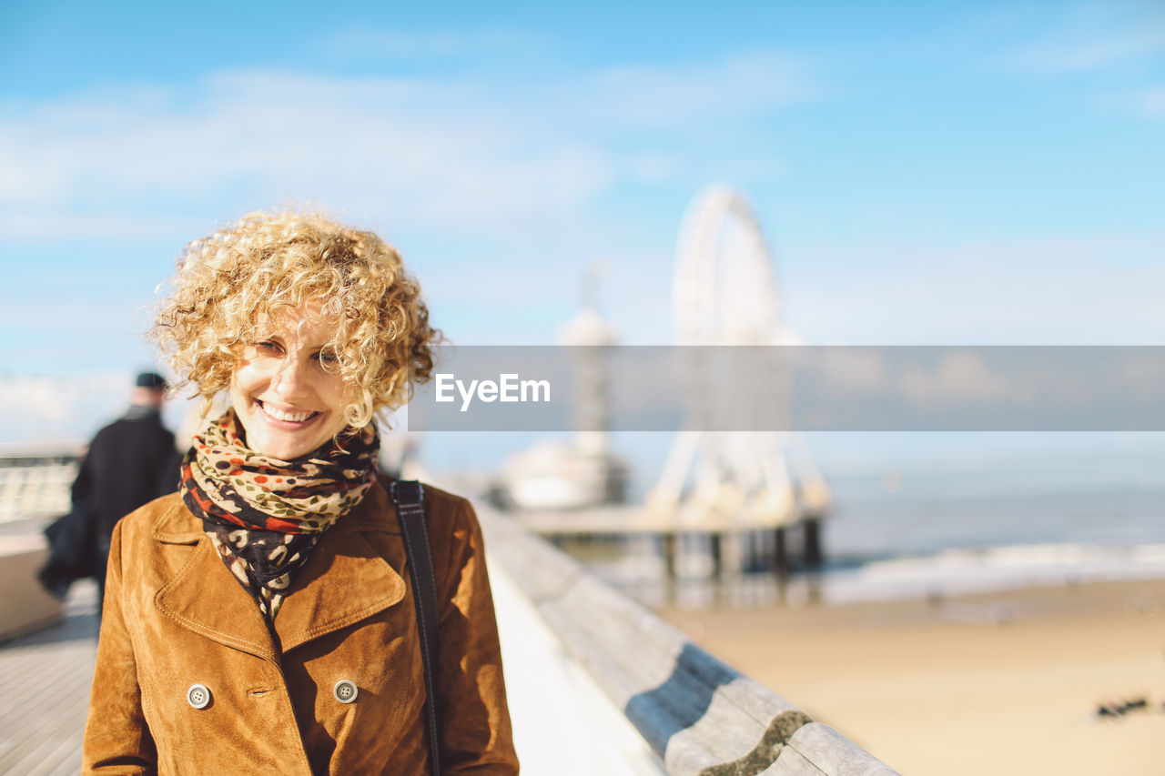 Portrait of smiling woman standing by the beach