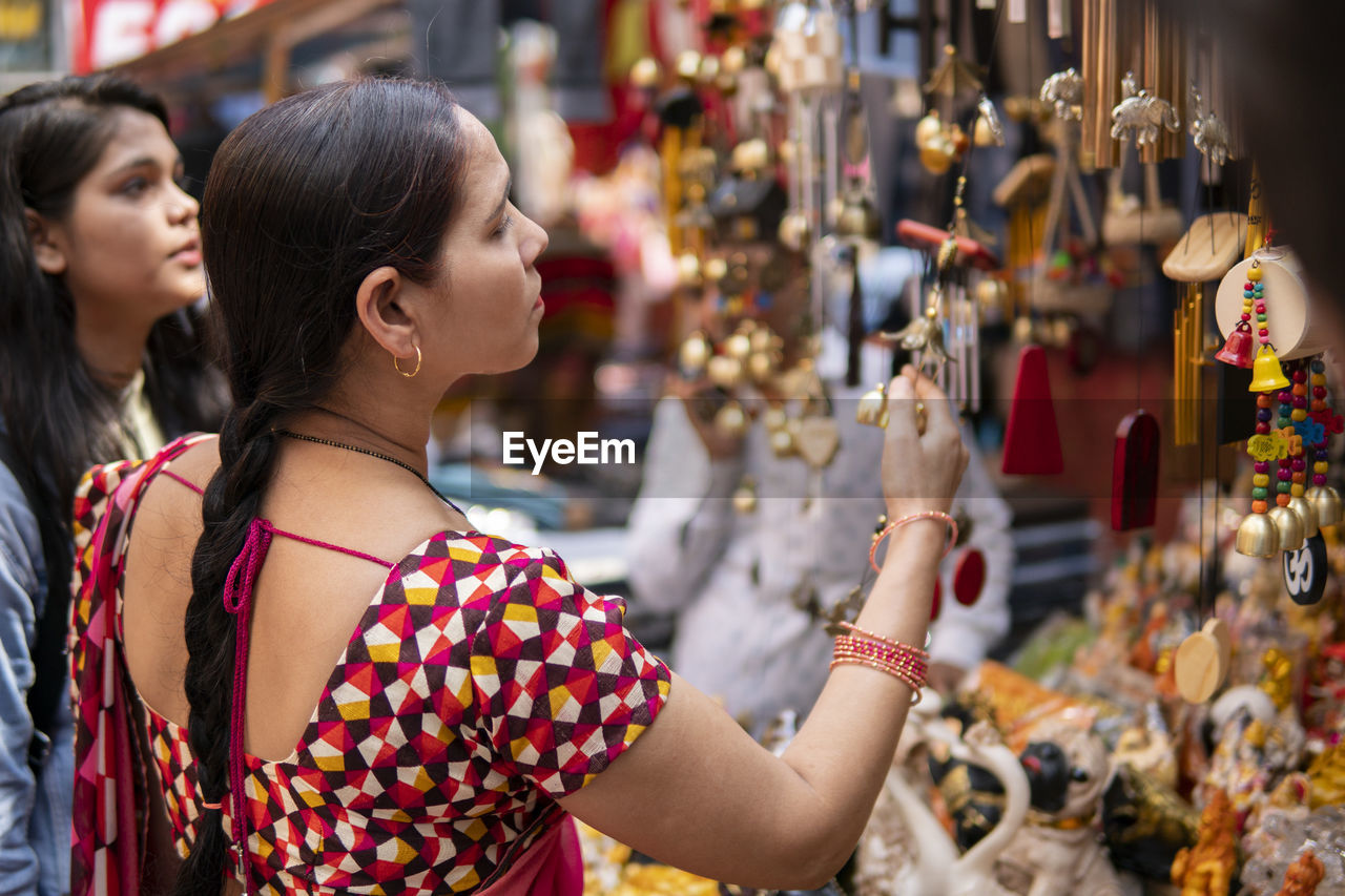 Mother daughter by decoration at market stall