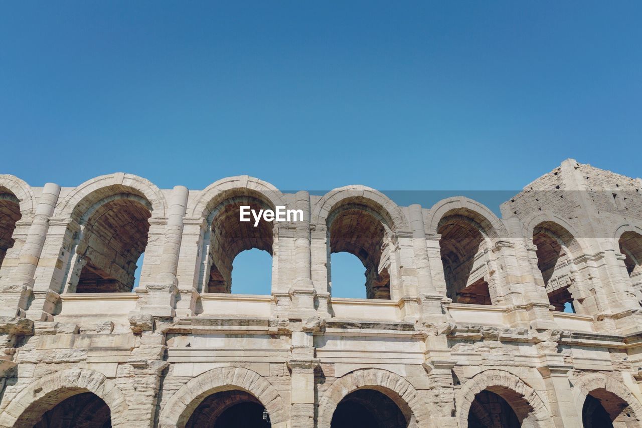 Low angle view of arles amphitheatre against clear sky