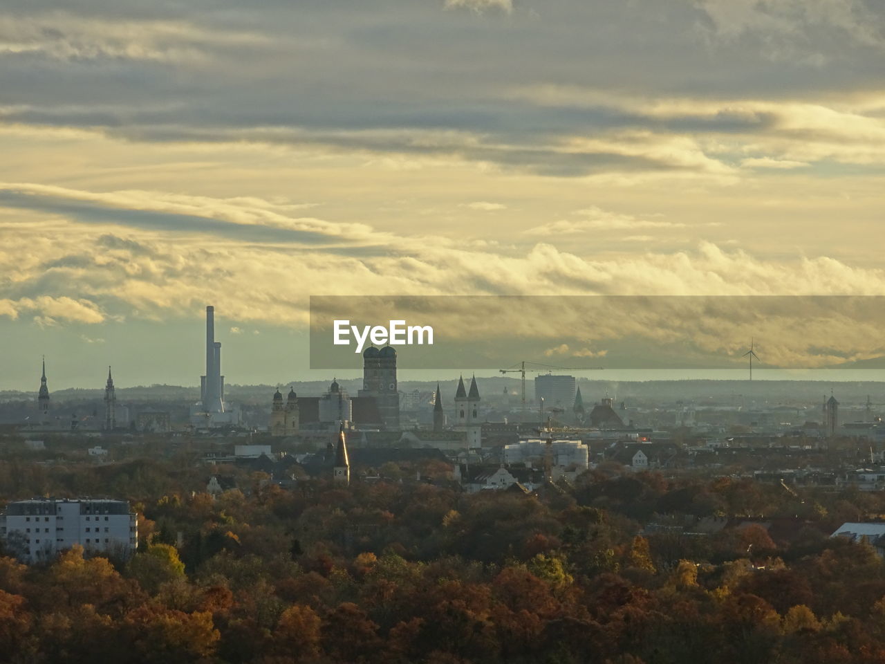 Cityscape by sea against sky during sunset