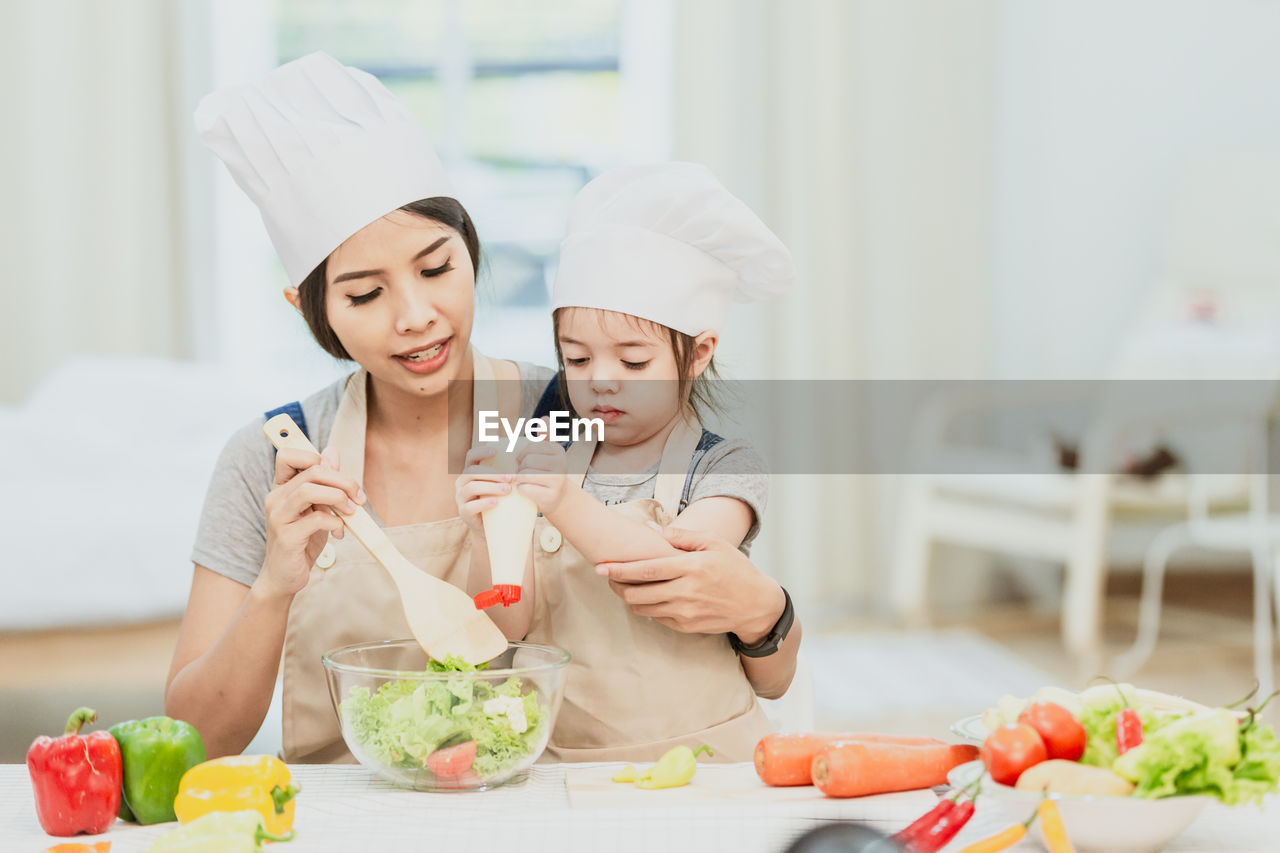 MIDSECTION OF WOMAN PREPARING FOOD