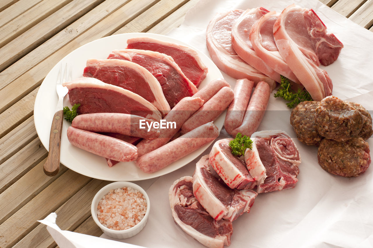 High angle view of various meat on wooden table