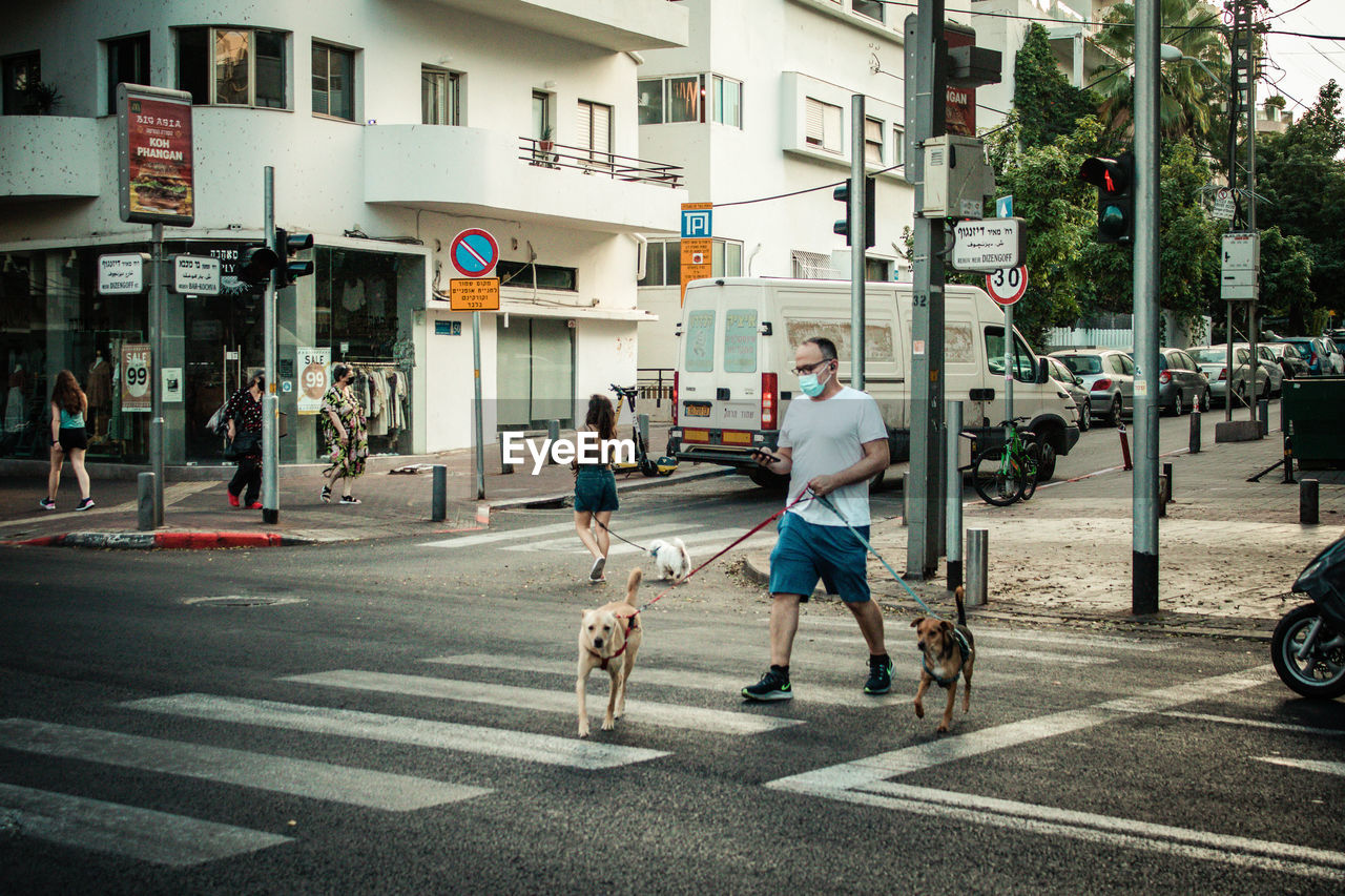 PEOPLE ON ROAD IN CITY