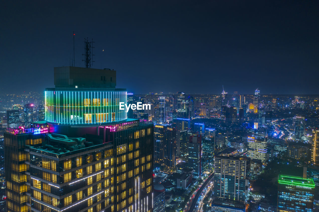 ILLUMINATED BUILDINGS AGAINST SKY AT NIGHT