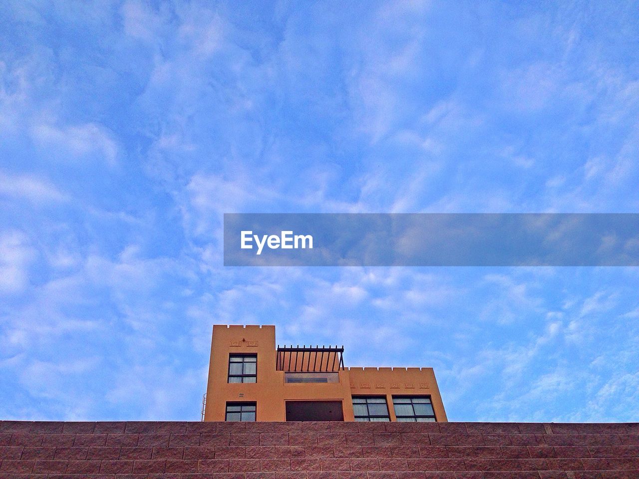 LOW ANGLE VIEW OF BUILDINGS AGAINST BLUE SKY