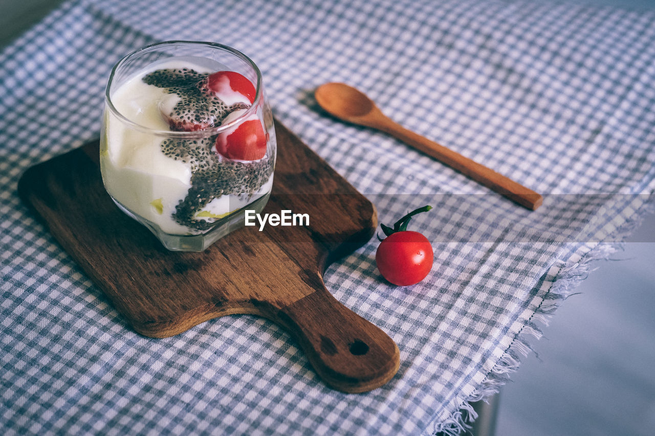 High angle view of cherry tomatoes and yogurt on table