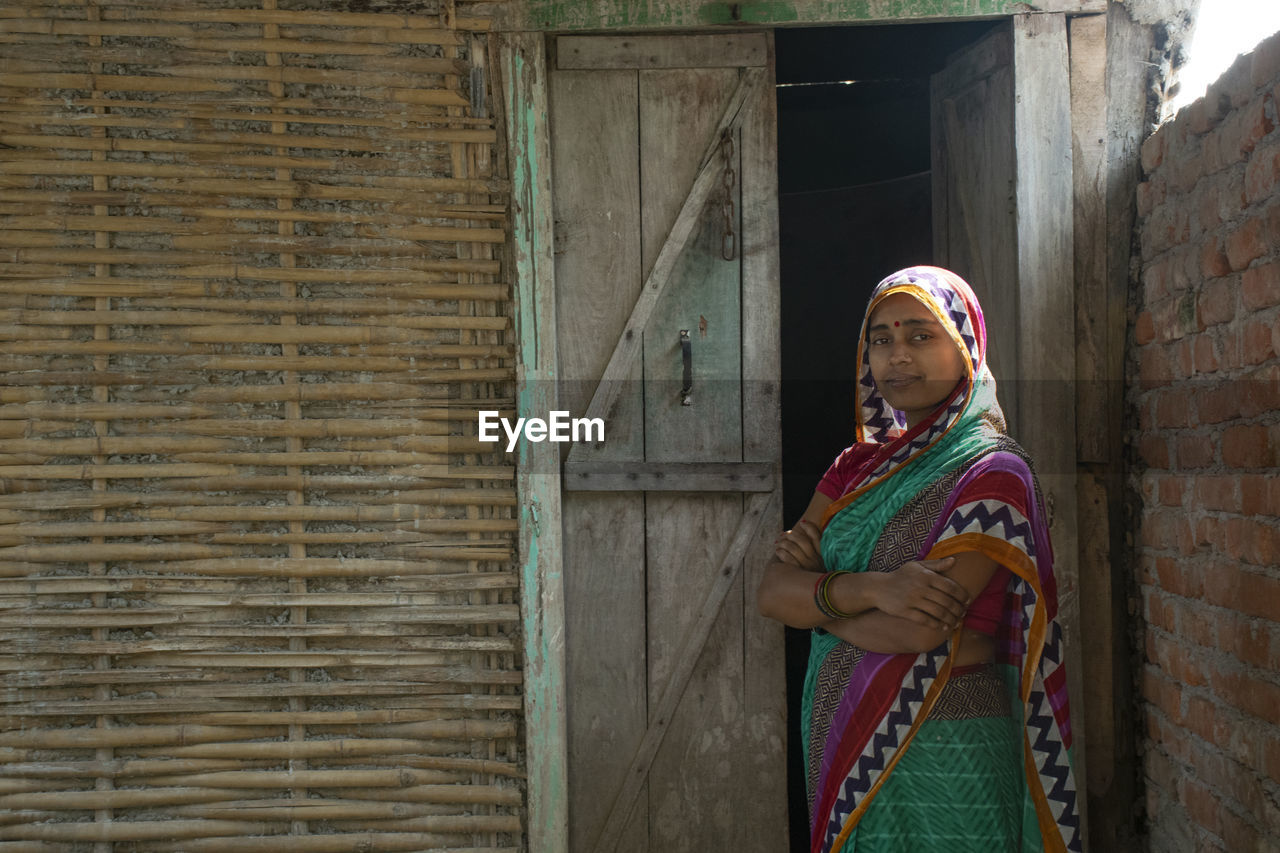 Portrait indian of woman wearing sari standing against door