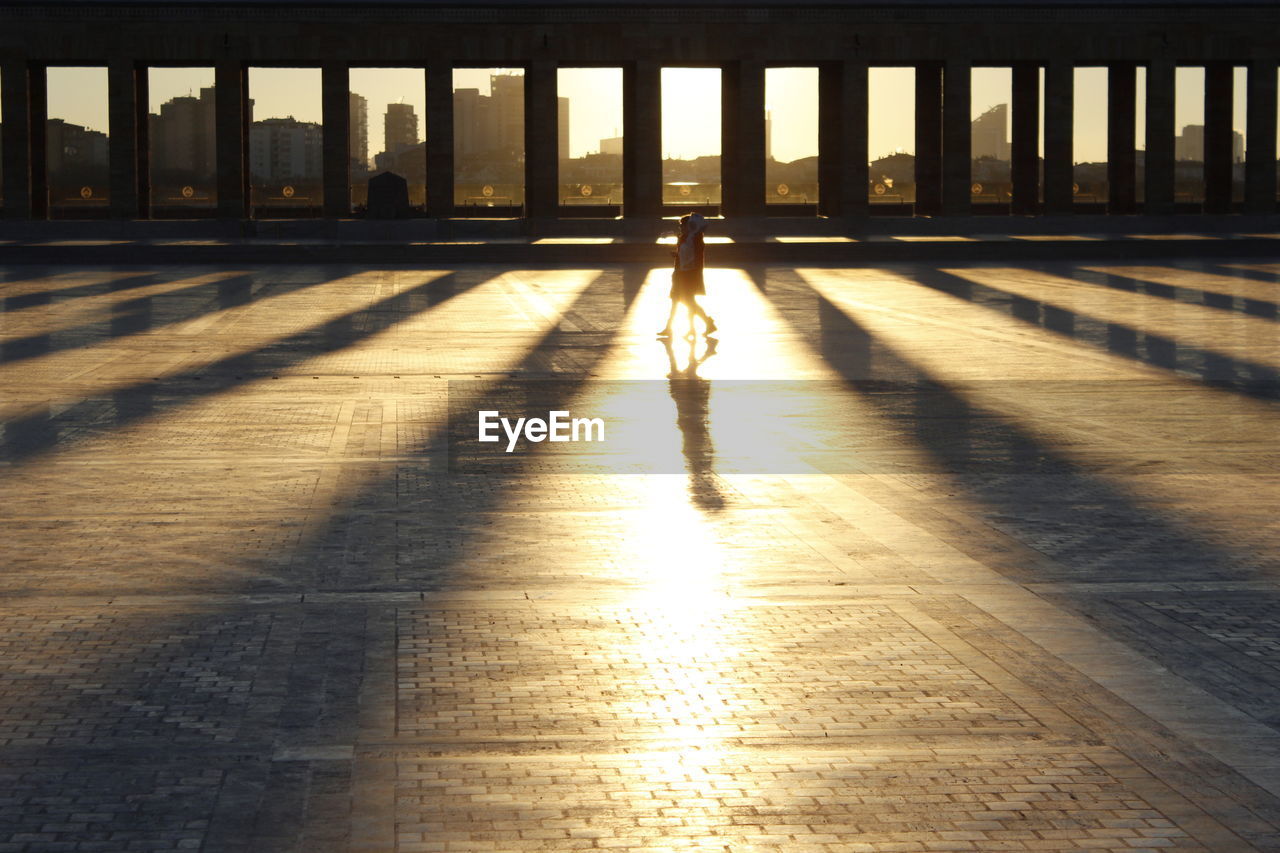 SHADOW OF PERSON ON FLOOR AT BUILDING