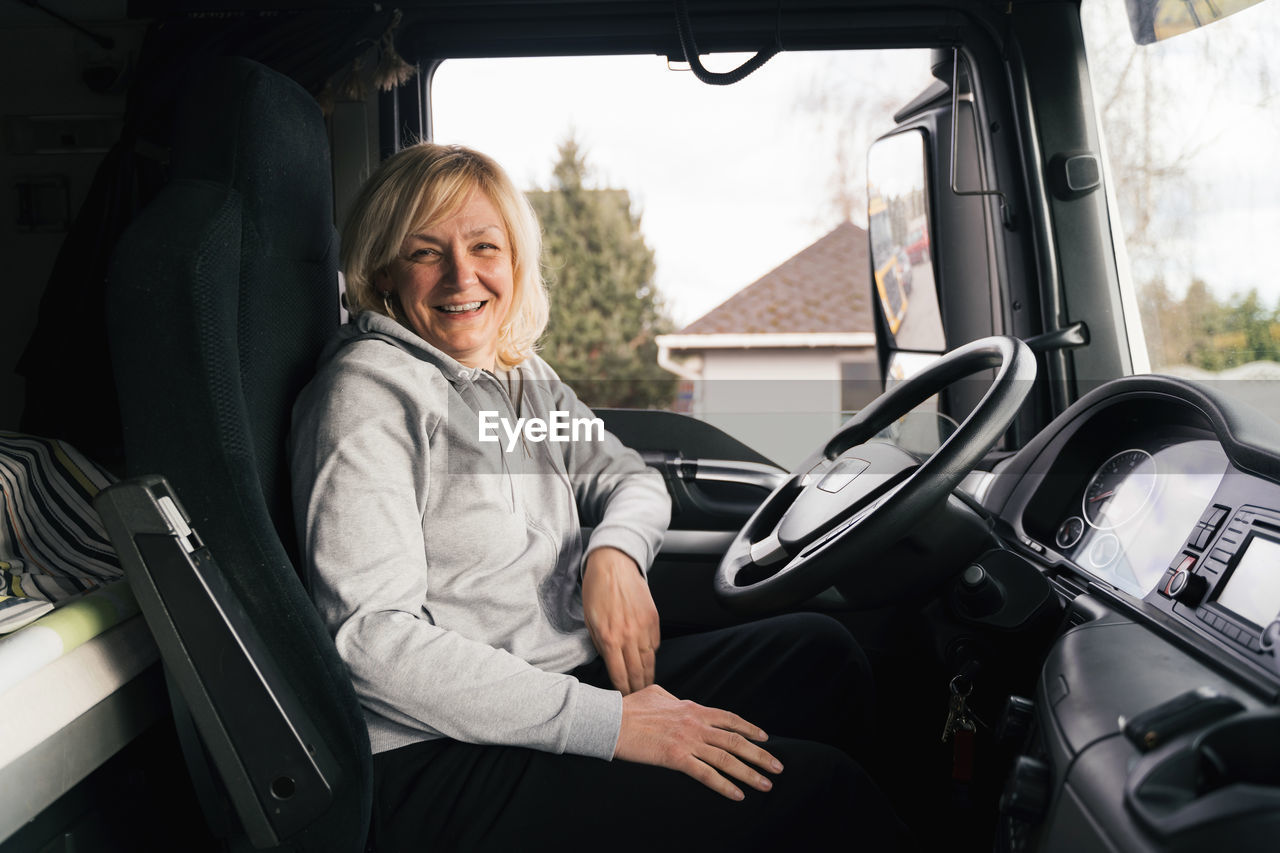 portrait of smiling woman sitting in car