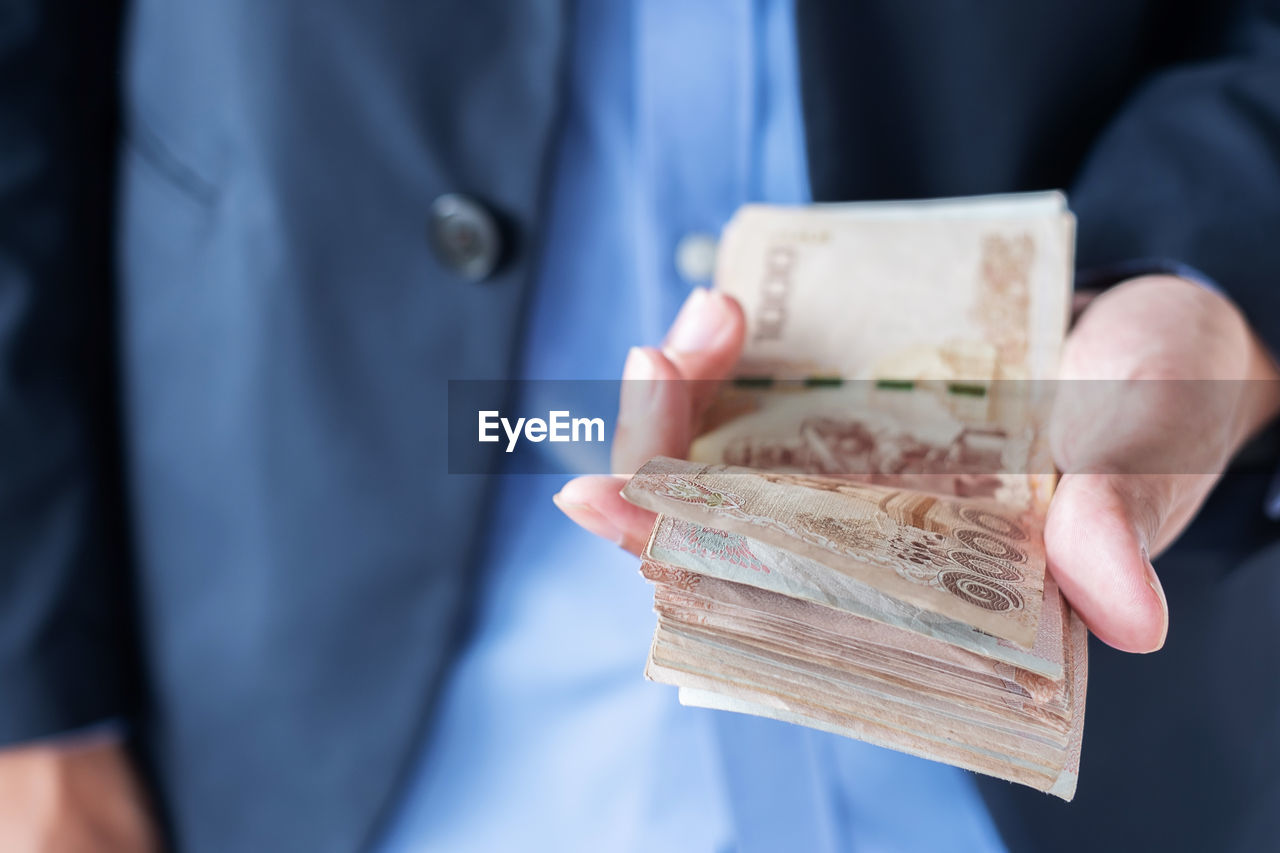 Midsection of businessman counting money