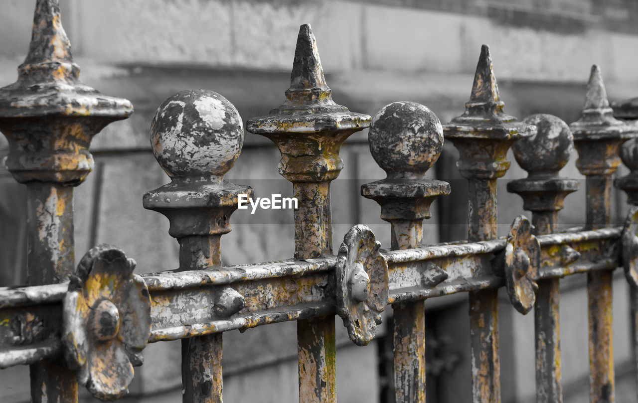 Close-up of rusty metal chain against fence